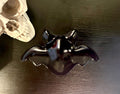 Smokey grey bat-shaped resin catch-all bowl on dark surface