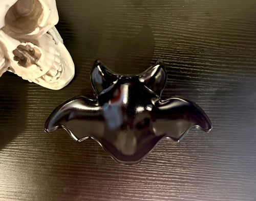 Smokey grey bat-shaped resin catch-all bowl on dark surface